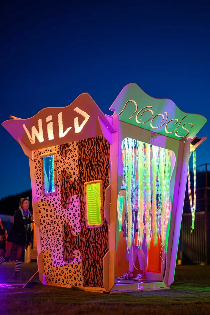 The Send Noods Box, a neon-lit walk-in photo booth glowing at night